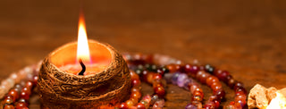 Gemstone Mala in a tranqiul setting with candle in a copper vessel